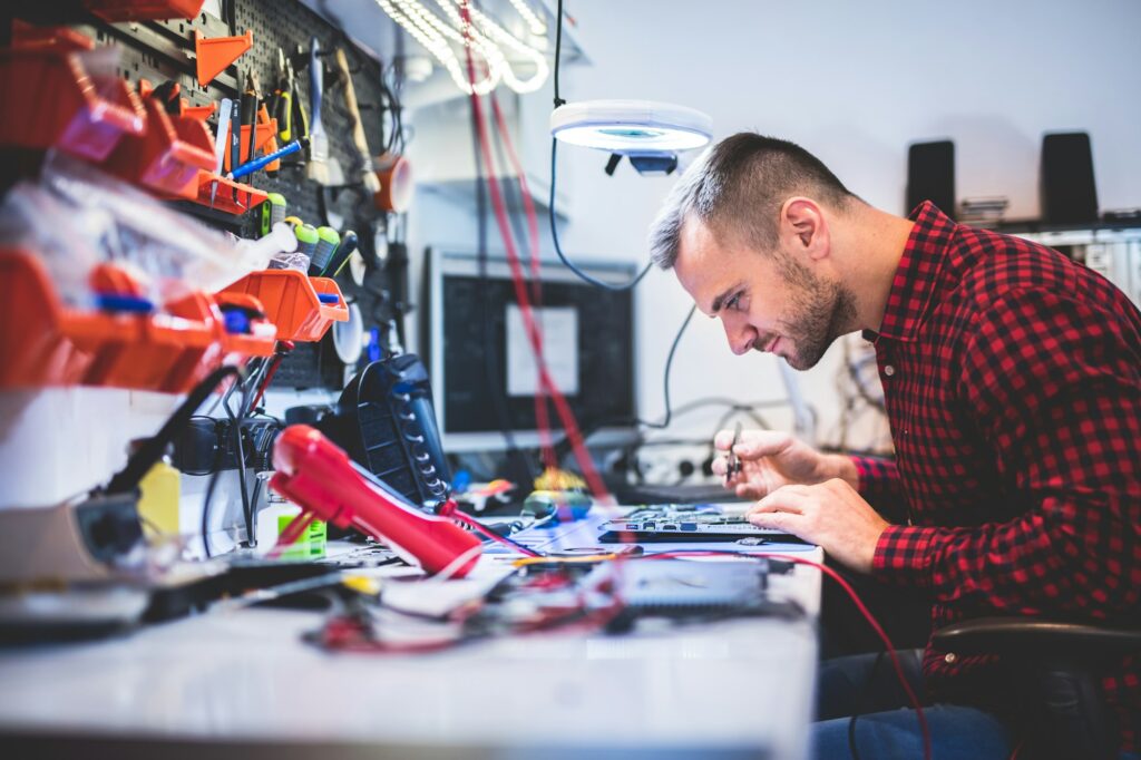 Man repairing laptop at workplace